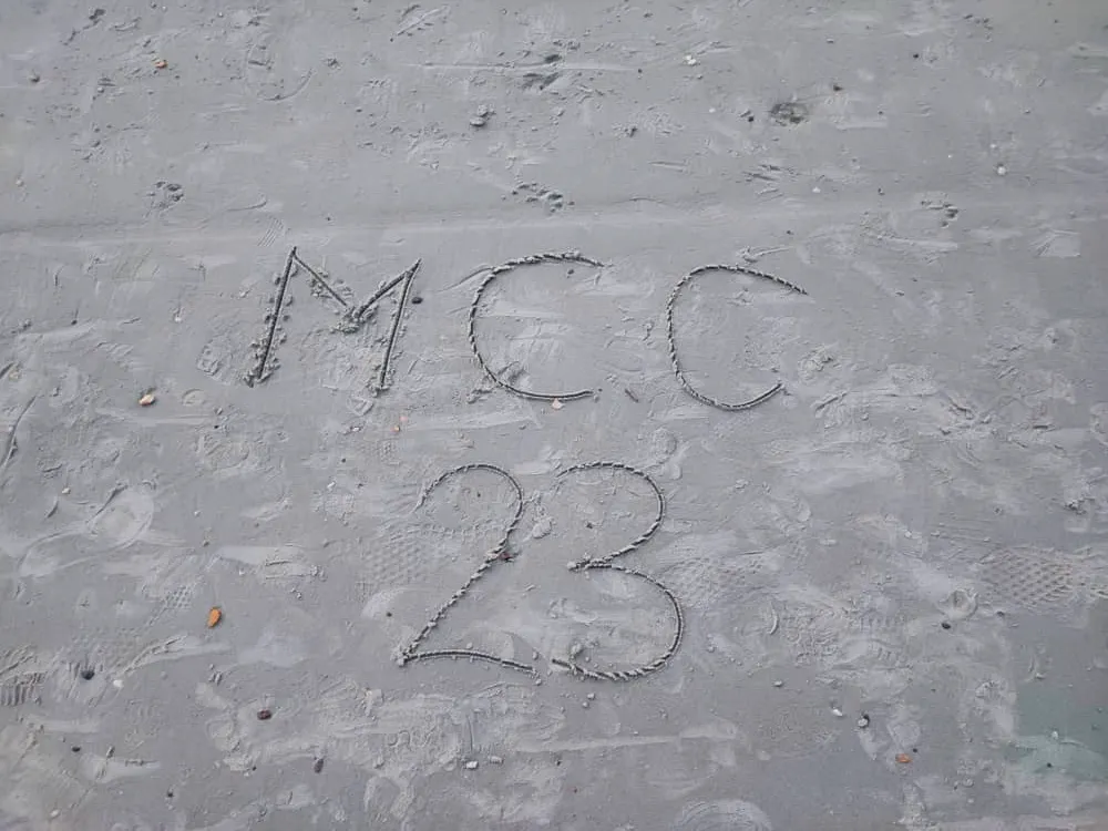 Image of MCC2023 written in the sand
